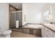 Bathroom featuring a glass-enclosed shower, soaking tub, toilet, and vanity with tiled floors and modern finishes at 1522 Willow St, Denver, CO 80220