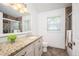 Bright bathroom featuring a single vanity with a granite countertop, toilet and tub at 1522 Willow St, Denver, CO 80220