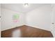 Empty bedroom featuring hardwood floors, base molding and a window at 1522 Willow St, Denver, CO 80220