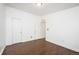 Empty bedroom featuring hardwood floors, base molding and two closets with white doors at 1522 Willow St, Denver, CO 80220