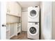 Cozy laundry room area featuring white cabinets, a stacked washer and dryer, and ample storage space at 1522 Willow St, Denver, CO 80220