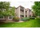 Inviting condo exterior featuring a lush lawn and two-story facade with quaint balcony at 9263 E Arbor Cir # B, Englewood, CO 80111
