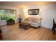 Bright living room showcasing a comfortable beige sofa, an ottoman, and a large window with lush green views at 9263 E Arbor Cir # B, Englewood, CO 80111