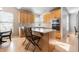 Well-lit kitchen featuring light wood cabinets, an island with seating, and modern appliances at 16456 Wagon Pl, Parker, CO 80134