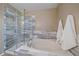 Bright, neutral bathroom featuring a glass-enclosed shower and a soaking tub at 3528 Morning Glory Dr, Castle Rock, CO 80109