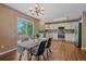 Bright dining area adjacent to the kitchen with a modern chandelier and sliding door access to outdoor deck at 3528 Morning Glory Dr, Castle Rock, CO 80109