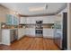 Modern kitchen featuring stainless steel appliances, white cabinetry, granite countertops and wood flooring at 3528 Morning Glory Dr, Castle Rock, CO 80109