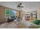 Inviting living room featuring a ceiling fan, natural light, and an open-concept view to the kitchen at 3528 Morning Glory Dr, Castle Rock, CO 80109