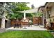 Outdoor patio with shade covering, dining table, grill, garden, and gate leading to lush green yard at 6080 S Detroit St, Centennial, CO 80121
