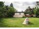 Spacious backyard with lush green grass, mature trees, and well-maintained brick exterior at 6080 S Detroit St, Centennial, CO 80121