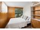 Bedroom with wood paneled walls, white bed, mountain mural, and built-in storage at 6080 S Detroit St, Centennial, CO 80121