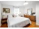 Cozy bedroom with a plush white bed, wooden furniture, and natural light streaming through the window at 6080 S Detroit St, Centennial, CO 80121