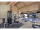 Bright gym with high ceilings, wood beams, multiple workout machines and an adjacent sitting area with a fireplace at 7201 E Quincy Ave # 103, Denver, CO 80237