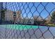 Outdoor tennis court viewed through a chain link fence on a sunny day at 7201 E Quincy Ave # 103, Denver, CO 80237