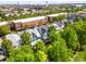An aerial shot reveals closely nestled homes, surrounded by mature trees, and urban buildings at 7899 E 28Th Pl, Denver, CO 80238