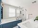 Bright bathroom features a soaking tub with stylish blue paneling and a glass-enclosed shower at 7899 E 28Th Pl, Denver, CO 80238