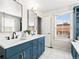 Bathroom featuring double sinks with blue cabinets and white countertops at 7899 E 28Th Pl, Denver, CO 80238