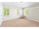 Light filled bedroom includes three windows with lovely backyard view and modern hanging chair at 7899 E 28Th Pl, Denver, CO 80238