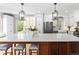 Bright kitchen featuring a large island with seating, stainless steel appliances, and pendant lighting at 7899 E 28Th Pl, Denver, CO 80238