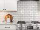 Close-up of a modern kitchen featuring a stainless steel stove, backsplash, and contemporary design at 7899 E 28Th Pl, Denver, CO 80238