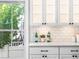 Bright, modern kitchen, featuring white cabinets, tiled backsplash, and a view to the outdoors at 7899 E 28Th Pl, Denver, CO 80238