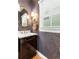Stylish powder room with dark wallpaper, elegant vanity, and modern fixtures at 7899 E 28Th Pl, Denver, CO 80238