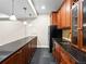 Wet bar features dark wood cabinetry, granite countertop, stainless steel sink, and tile backsplash at 7899 E 28Th Pl, Denver, CO 80238