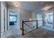 Upstairs hallway with neutral carpet, white railing, and views into bedrooms at 1873 Trevor Cir, Longmont, CO 80501