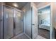 Glass-enclosed shower with white tile and modern fixtures, adjacent to a bedroom with a white bed at 1873 Trevor Cir, Longmont, CO 80501