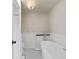 Well-lit bathroom featuring a modern tub, tiled floors, and white walls at 8035 S Garfield Way, Centennial, CO 80122