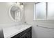 Updated powder room with sleek vanity, chrome fixtures, wainscoting and a frosted window allowing for natural light at 8035 S Garfield Way, Centennial, CO 80122