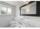 Elegant bathroom showcasing a marble countertop, large mirror, and black and white patterned floor at 8035 S Garfield Way, Centennial, CO 80122