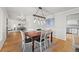 Stylish dining room with a wooden table, modern light fixture, and view into the living room at 8035 S Garfield Way, Centennial, CO 80122