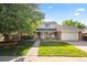 Charming two-story home with a well-manicured lawn, beautiful tree, and inviting front porch at 8035 S Garfield Way, Centennial, CO 80122