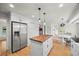 Bright kitchen features a butcher block island, stainless steel refrigerator, white cabinets, and hardwood floors at 8035 S Garfield Way, Centennial, CO 80122