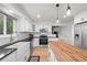 Well-lit kitchen featuring a butcher block island, stainless steel appliances, white subway tile and black countertops at 8035 S Garfield Way, Centennial, CO 80122