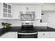 Close up of stainless steel microwave and range above a smooth top stove set into white cabinets at 8035 S Garfield Way, Centennial, CO 80122