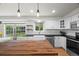 Kitchen features a butcher block island, stainless steel appliances, a white farmhouse sink, and a window view at 8035 S Garfield Way, Centennial, CO 80122