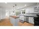 Kitchen with butcher block island, stainless steel appliances, white subway tile, black counters and adjacent breakfast nook at 8035 S Garfield Way, Centennial, CO 80122