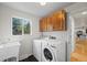 Laundry room features a white washer and dryer set, utility sink, and overhead storage cabinets at 8035 S Garfield Way, Centennial, CO 80122