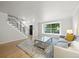 Bright living room with hardwood floors, a large window, comfortable seating, and a modern staircase at 8035 S Garfield Way, Centennial, CO 80122