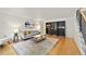 Inviting living room with hardwood floors, a cozy sofa, stylish rug, and built-in shelving at 8035 S Garfield Way, Centennial, CO 80122