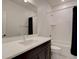 Modern bathroom with a dark vanity, white countertop, tub and shower with a dark shower curtain at 11246 Bellsong Ln, Littleton, CO 80125