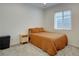 Neutral bedroom featuring a queen bed and bedside table bathed in natural light from the window at 11246 Bellsong Ln, Littleton, CO 80125