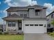 Charming two-story home with a two car garage, attractive gray siding, and well-maintained landscaping at 11246 Bellsong Ln, Littleton, CO 80125