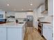 Bright, open-concept kitchen featuring stainless steel appliances, white cabinets, and a central island with seating at 11246 Bellsong Ln, Littleton, CO 80125