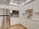 Bright kitchen with stainless steel appliances, white cabinets, and modern lighting at 11246 Bellsong Ln, Littleton, CO 80125