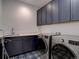 Laundry room featuring front load washer and dryer, as well as navy cabinets at 11246 Bellsong Ln, Littleton, CO 80125