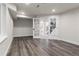 Finished basement with gray wood floors and white trim, leading to stairs with black metal handrail at 10 Summit Ash, Littleton, CO 80127