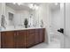 Bathroom featuring a double sink vanity with a large mirror and modern lighting at 10 Summit Ash, Littleton, CO 80127